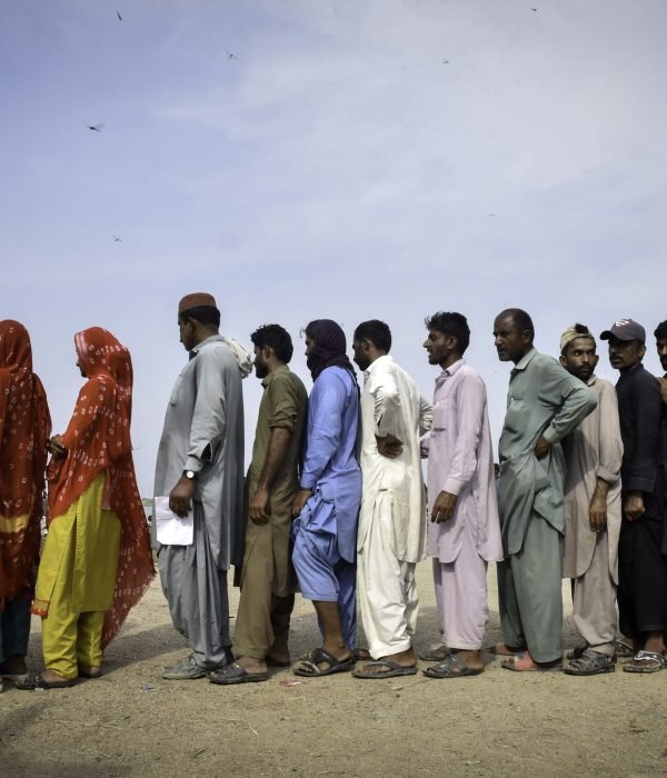 Pessoas deslocadas pelas enchentes esperam na fila por pacotes de ajuda. Flood affected people wait in line for relief packages. Photo by: © European Union, 2022 (photographer: Abdul Majeed)